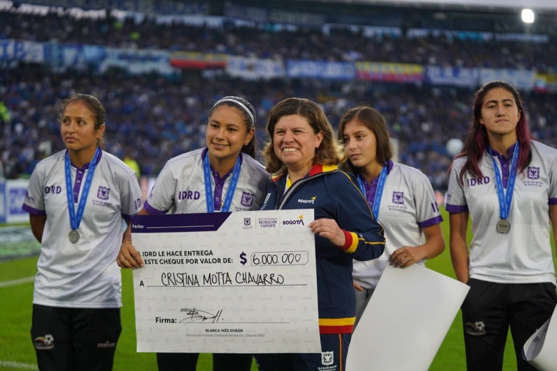 La directora del IDRD Blanca Durán entregando un cheque a una de las jugadoras
