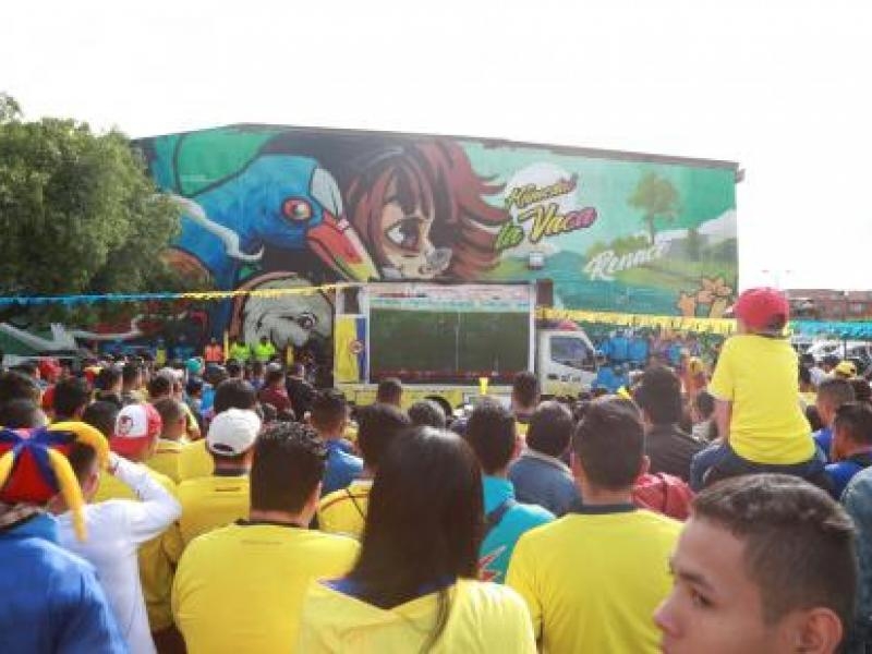 Personas ven partido de fútbol en pantalla gigante